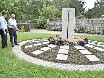 Rund um eine Stele sind in Zukunft im Friedhof von Königsberg Urnenbestattungen möglich. Pfarrer Peter Hohlweg und Bürgermeister Claus Bittenbrünn (von links) besprachen die Einzelheiten vor Ort.  Foto: Gerold Snater