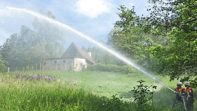 Die Rampertsm&uuml;hle im Wald bei Nassach war das angenommene Brandobjekt. Die Feuerwehren "l&ouml;schten" den "Brand".  Fotos: Christian Licha