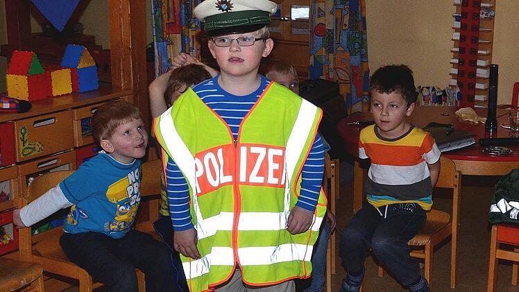 Tim darf die Warnweste anprobieren.