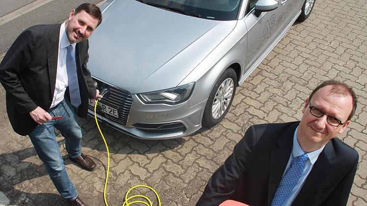 Pressesprecher Andreas Grosch (links) und Kreiskämmerer Holger Stingl laden die Batterie des neuen Hybridwagens des Landratsamtes an der Zapfsäule der Obermain-Therme in Bad Staffelstein wieder auf. Bis sie randvoll ist, dauert es rund zwei Stunden.  Foto: Andreas Schmitt