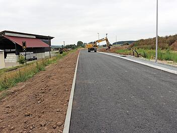 Nördlich der Bahnlinie wird in Mühlhausen derzeit das neue Baugebiet Hüttenfeld erschlossen. 17 Baugrundstücke sollen dort entstehen. Links im Bild ist eine Halle des örtlichen Unternehmens für Hackschnitzel zu sehen.  Foto: Evi Seeger