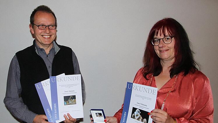 Ehre, wem Ehre gebührt: Ingrid Kronthaler, die Bezirksleiterin des DVF  (Deutscher Verband für Fotografie) Mainfranken (rechts) war nach  Münnerstadt gekommen, um Gerd Wetzels (links) die Medaille und die Urkunden  zu überreichen, die er bei der mainfränkischen Fotomeisterschaft errungen  hatte. Foto: Dieter Britz