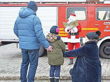 Die kleine Klara-Maria bleibt lieber zwischen Papa Henry und Mama Kathuna auf Distanz zum Nikolaus, der mit dem Feuerwehrauto ankam.