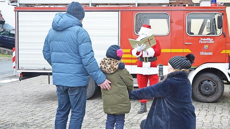 Die kleine Klara-Maria bleibt lieber zwischen Papa Henry und Mama Kathuna auf Distanz zum Nikolaus, der mit dem Feuerwehrauto ankam.