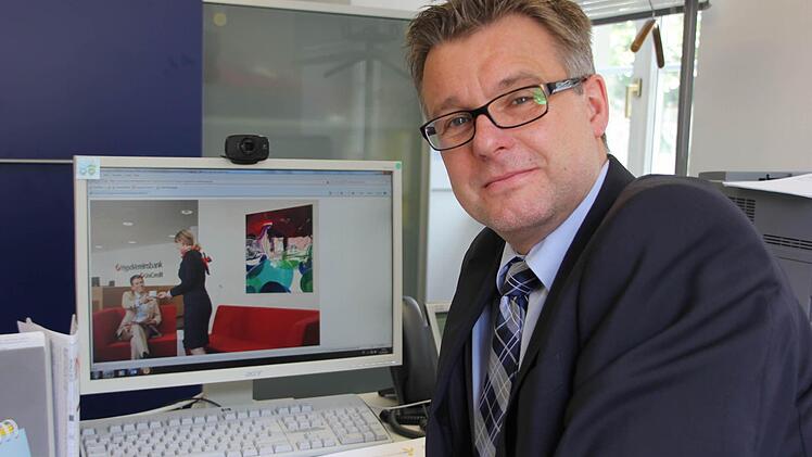 Ralf Baumann, Direktor der HypoVereinsbank-Filiale Kronach, zeigt am Bildschirm, wie gemütlich die Wartelounge werden soll.  Foto: Friedwald Schedel