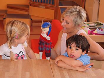Katrin Reitz, Erzieherin und Leiterin der Krippengruppe im städtischen Kindergarten Kunterbunt in Eltmann, spielt mit den Kindern ihrer Gruppe im Morgenkreis.  Foto: Friederike Stark
