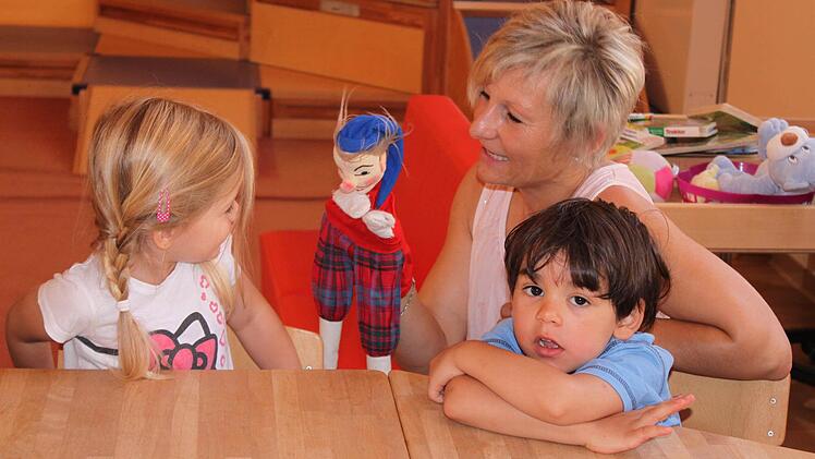 Katrin Reitz, Erzieherin und Leiterin der Krippengruppe im städtischen Kindergarten Kunterbunt in Eltmann, spielt mit den Kindern ihrer Gruppe im Morgenkreis.  Foto: Friederike Stark
