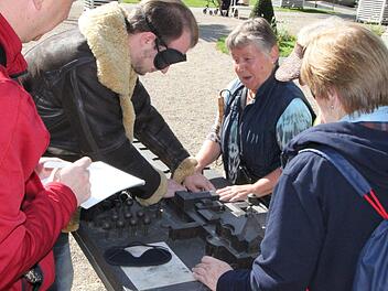 Test unter Anleitung: Gisela Schmitt und weitere Mitglieder des Bayerischen Blinden- und Sehbehindertenbundes sagen Reporter Johannes Schlereth auf was er beim Tasten mit Augenbinde achten muss. Vorne notiert Reporter Ralf Ruppert die Eindrücke der Beteiligten.Ulrike Müller