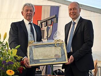 Landrat Kalb (links) überreichte Bürgermeister Karmann (rechts ) einen Faksimile-Druck der Originalurkunde von 1118. Foto: Andrea Spörlein