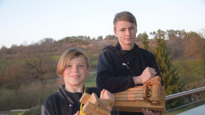 Die Brüder Alexander und Maxim Conze klappern in Zeiten der Corona-Krise vom Balkon aus. Zusammen mit vielen anderen Kindern aus Schondra übernehmen sie von Gründonnerstag Abend bis zur Osternacht den Dienst der Kirchenglocken. Foto: Horst Conze