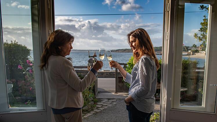 Während Dupin ermittelt, stoßen seine Frau Claire (Christina Gabriela Hecke, rechts) und seine Mutter Virginie Dupin (Tatja Seibt) zu Hause auf ihr Wiedersehen an.