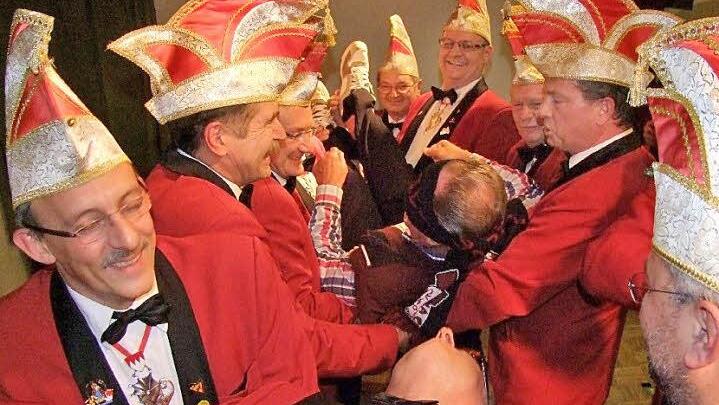 Was macht einen Elferrat zum Elferrat? Natürlich die Narrenkappe und die vorangegangene Taufe mit einem Gläschen Schnaps. Die neuen Elferräte Valentin Stöcklein und Adolf Stahl lassen, auf Händen getragen, die Prozedur über sich ergehen. Fotos: Sabine Berthold