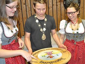 Fast andächtig betrachtet der neue Jugendschützenkönig Samuel Förster die soeben gewonnene Scheibe, eingerahmt von 1. Ritter Daniela Kern (links) und seiner Schwester Antonia Förster als 2. Ritter.Simon Albrecht