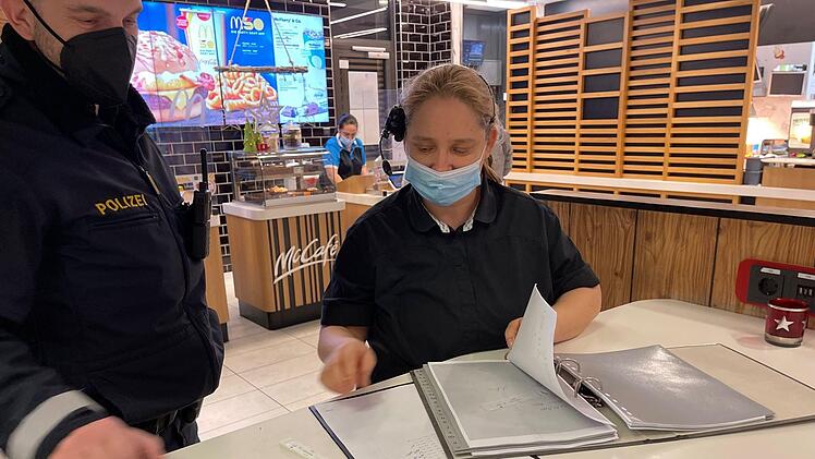 Die Schichtführerin des McDonald's in Brücklein,  Heidrun Arndt-Stadthaus, zeigt Einsatzleiter Thomas Müller die Listen mit den überprüften Mitarbeitern. Foto: Jürgen Gärtner