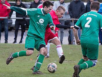 Der Neukenrother Torsch&uuml;tze Niklas Wich (rotes Trikot) setzt zum Torschuss an und Friesens Philipp Geiger versucht noch den Fu&szlig; vor den Ball zu bekommen.  Foto: Heinrich Wei&szlig;