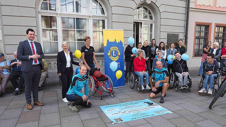 In 50 Tagen um Bayern: Ute Jansen und Markus Frommlet (vorn) umrunden mit verschiedenen Fortbewegungsmitteln den weiß-blauen Freistaat. Dabei verlassen sie sich nur auf die eigene Muskelkraft und sammeln mit und während der Reise Spenden für die Sportinklusion. Der Lions Club Coburg Veste mit Präsidentin Dorothée Sinha, rechts neben OB Dominik Sauerteig (links), übergab am Freitag einen Basketball-Rollstuhl dem Turnverein 1848 und seiner Vorsitzenden Astrid Hess (3. von links). Foto: Christop...