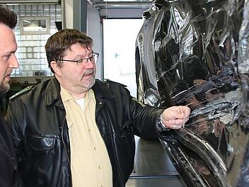 Kfz-Meister Alexander M&uuml;ller und Polizist Joachim Reininger begutachten einen Schaden: Wenn es sich hier um eine Unfallflucht gehandelt h&auml;tte, w&uuml;rde die eingeklemmte Glasscherbe vom gegnerischen Fahrzeug R&uuml;ckschl&uuml;sse auf die Fahrzeugmarke zulassen. Foto: Ralf Ruppert