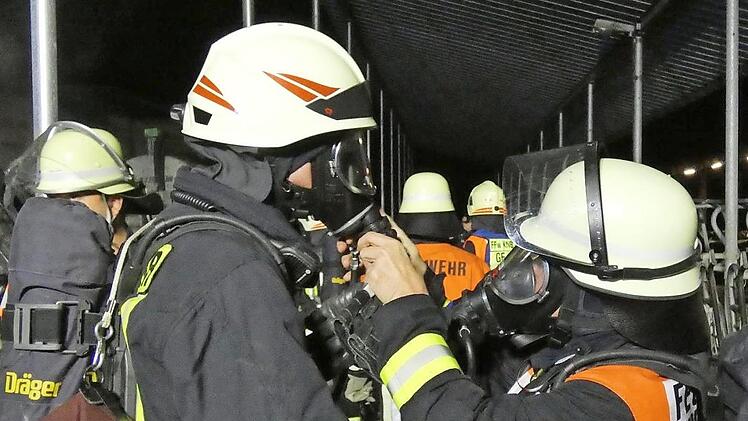 Nur unter Atemschutz konnte das Feuer gelöscht werden. Die Einsatzkräfte halfen sich gegenseitig beim Anlegen der Ausrüstung.
