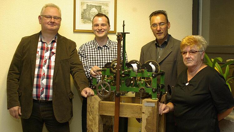 Mit dem historischen Turmuhrwerk ist ein Stück Geschichte nach Aura zurückgekehrt über das sich Restaurator Josef Drost, Andreas Schaupp, Bürgermeister Thomas Hack und Initiatorin Renate Graser freuen. Foto: Winfried Ehling
