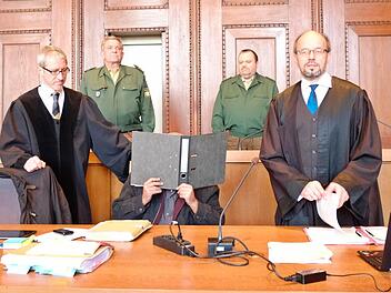 Der Angeklagte verbirgt sein Gesicht zwischen seinen Verteidigern Klaus Lustig (l.) und Inigo Schmitt-Reinholtz. Foto: Nikolas Pelke