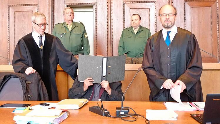 Der Angeklagte verbirgt sein Gesicht zwischen seinen Verteidigern Klaus Lustig (l.) und Inigo Schmitt-Reinholtz. Foto: Nikolas Pelke