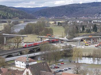 Kurioser Anblick in Gemünden: Beim Abriss des ersten Teilstücks der Mainbrücke stürzte ein Teil zu viel ein. Jetzt steht ein Bagger isoliert da. Doch Züge können dennoch unten durchfahren. Foto: Jens Jedamzik