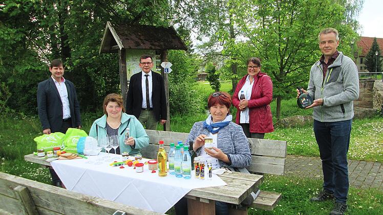 Zum Wandern und Fahrradwandern gehört eine zünftige Brotzeit, die der Allianz-Picknickbeutel bietet. Dafür werben (von links) Holger Becker, Allianz-Vorsitzender Armin Warmuth, Stephanie Kunder, Thomas Beck sowie (sitzend von links) Stefanie  Kirchner (Brennerei Bürger) und Helene Greubel (Bunter Bauernladen).