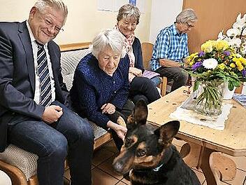 Therapiehund Kurti gratulierte, indem er der Jubilarin die Pfote reichte. Bürgermeister Frank Wilzok, die Jubilarin Marga Schmidt, Tochter Christine Eßer-Böhner und Karl-Heinz Knorreck konnten sich ein Lachen nicht verkneifen.