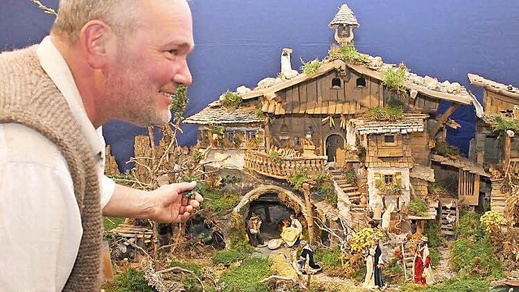 Michael Hoffmann bestaunt seine eigenes alpenländisches Krippenhaus, das sogar mit Ankleidefiguren aufwarten kann.  Fotos: fra-press