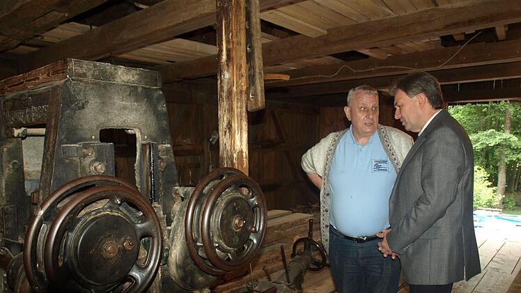 Der erste Schneidmüller Bernhard Schlee (links) erklärt dem Mühlvogt und Landrat Klaus Löffler das königlich-bayerische Eisenvollgatter. Foto: Susanne Deuerling