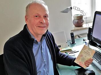 Rainer Haak hält das erste Buch der dreibändigen Reihe, "77 mal Dankbarkeit" aus dem Jahr 2018, in den Händen. Foto: Archiv/Sigismund von Dobschütz