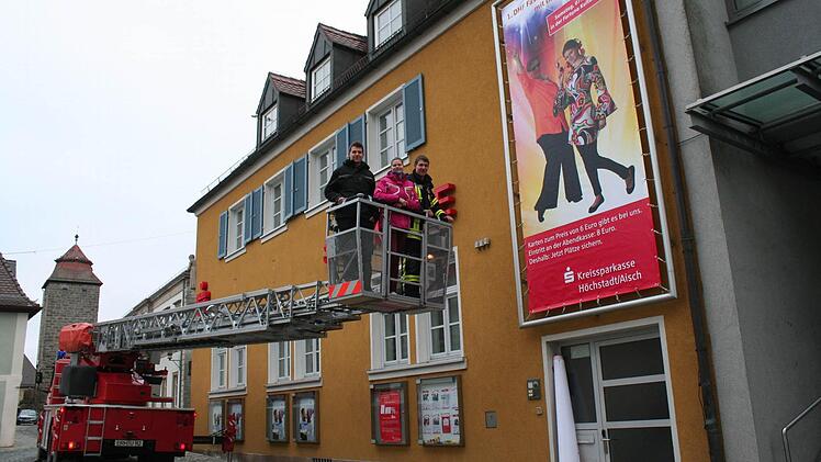 Markus Ort, Julia Woiton und Michael Ort (v. l.) begutachten vom Drehleiterkorb aus das Plakat. Foto: Evi Seeger