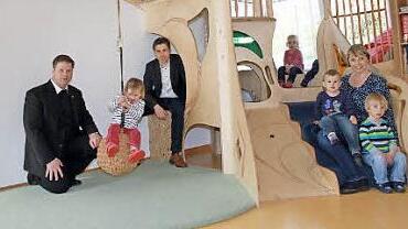 Pfarrer Steffel (l.) und Bürgermeister Gunselmann (3.v.l.) schauen sich in der neugestalteten Krippe um.  Foto: Mathias Erlwein
