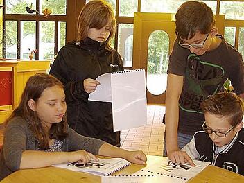 Charlotte, Sophia, Luis und Julian betrachten den neuen Grafik-Haiku-Kalender.  Foto: hs