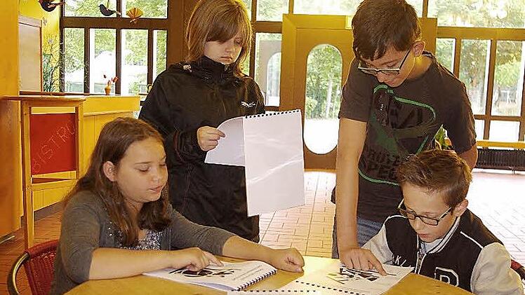 Charlotte, Sophia, Luis und Julian betrachten den neuen Grafik-Haiku-Kalender.  Foto: hs