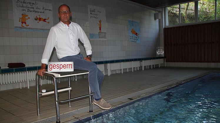 Wildfleckens Bürgermeister Gerd Kleinhenz am Beckenrand des Hallenbades. Wann das Schild "gesperrt" auftaucht, dürfte nur eine Frage der Zeit sein. Denn der Zahn der Zeit nagt am Schwimmbad unaufhörlich. Foto: Ulrike Müller