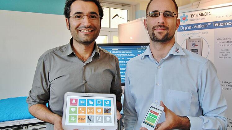 ZTM-Geschäftsführer Asurnusch Rashid (links) mit dem Senioren-Tablet, rechts hält IT-Systembetreuer Björn Koch ein Smartphone mit der Notfall-Meldung. Foto: Sigismund von Dobschütz