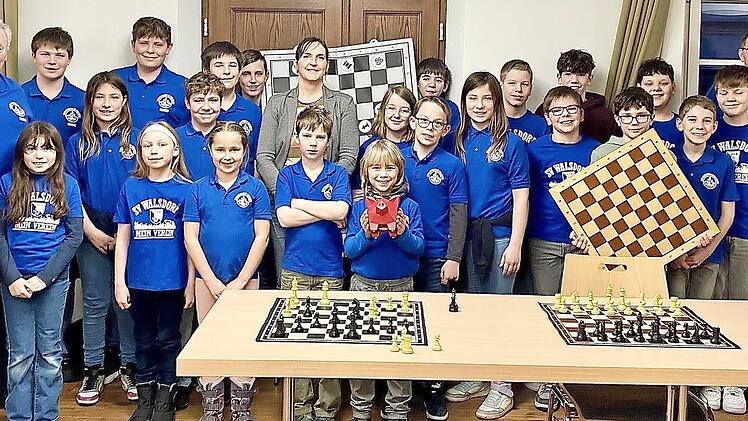 Spenden&uuml;bergabe durch &bdquo;Franken helfen Franken&ldquo;-Vorstandsmitglied Jessica Nickel (Bildmitte): Neben den Kindern und Jugendlichen waren auch Wolfgang Rottmann, Leiter der Schachabteilung des SV Walsdorf (l.) sowie die Trainer und Spieler Manfred Sta...