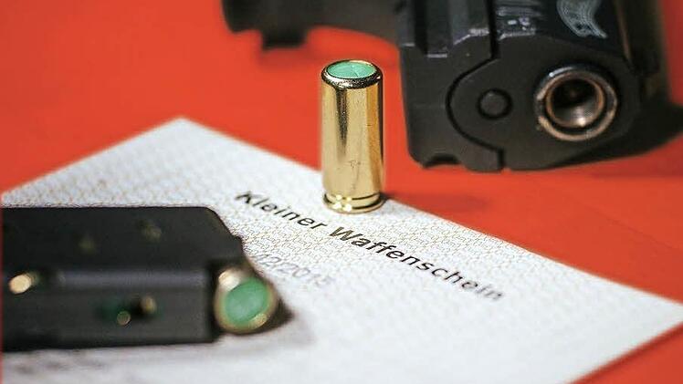 Ein Kleiner Waffenschein liegt zwischen einer Schreckschuss-Pistole Walther P22, einem Magazin und einer Platzpatrone.  Foto: Oliver Killig , dpa