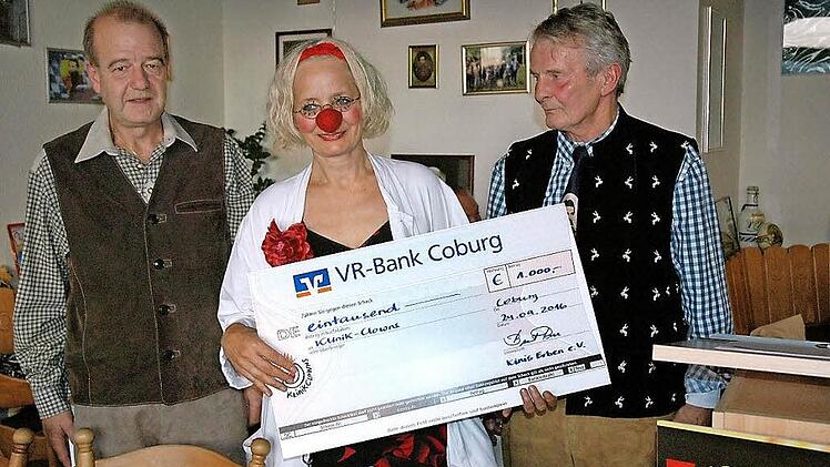 Zweiter Vorsitzender Uwe Forkel (links) und Vorsitzender Bernt Rose (rechts) von Kinis Erben überreichten an Klinikclown Dr. Kaala Knuffl einen Scheck in Höhe von 1000 Euro.  Foto: Edwin Meißinger