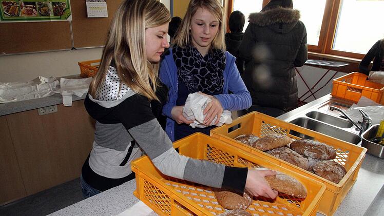 Sinja (l.) und Elisabeth verteilen das Brot in der Schule. Fotos: Michael Busch