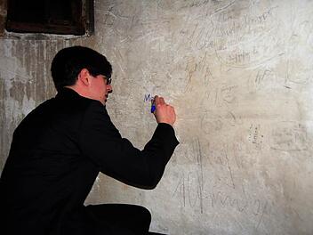 Eine heimliche, aber wichtige Unterschrift: Jeder, der schon einmal an der Orgel der Stiftskirche gespielt hat, wie auch Manuel Höppner, schreibt seinen Namen an die Wand des Treppenaufgangs.  Foto: A. Welz