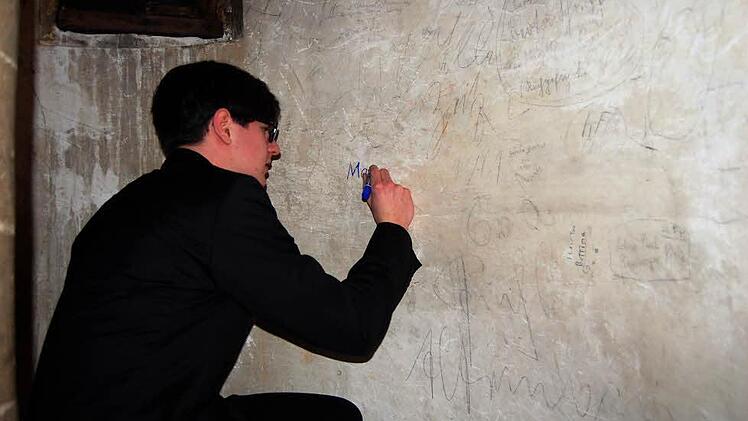 Eine heimliche, aber wichtige Unterschrift: Jeder, der schon einmal an der Orgel der Stiftskirche gespielt hat, wie auch Manuel Höppner, schreibt seinen Namen an die Wand des Treppenaufgangs.  Foto: A. Welz