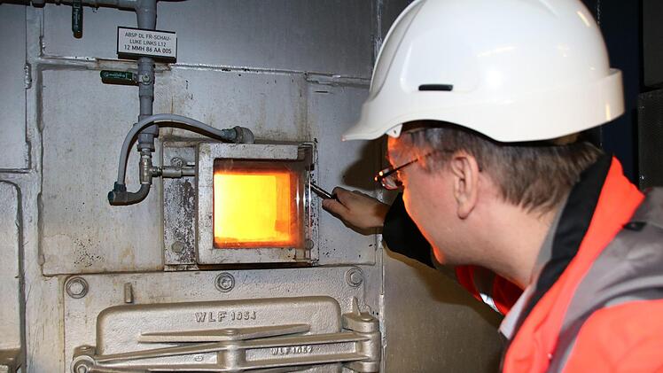 Dominik Reinig schaut  in den Müllverbrennungsofen im Gemeinschaftskraftwerk in Schweinfurt.