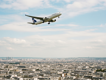 Ein Flugzeug fliegt &uuml;ber Paris.
