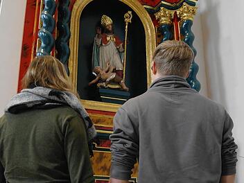 Ein Paar betrachtet die Darstellung des Heiligen Valentin auf dem Seitenaltar in der Klosterkirche Volkersberg.  Foto: Stephanie Elm
