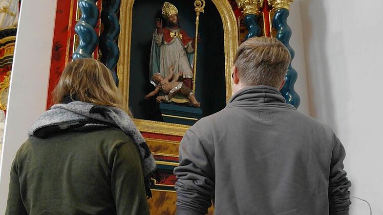 Ein Paar betrachtet die Darstellung des Heiligen Valentin auf dem Seitenaltar in der Klosterkirche Volkersberg.  Foto: Stephanie Elm