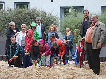 Einmal buddeln, bitte: Die Kinder des Kronacher Montessori Kinderhorts kamen dieser Bitte nur zu gerne nach - auch bei Regenwetter. Mit im neuen Sandkasten sind Kreisgeschäftsführerin der Caritas Cornelia Thron (links), daneben Hortleiterin Silke Leidner, sowie Hans Georg Simon (vorne rechts) und Philipp Mahrs (links daneben) von der Firma Reluma.  Foto: Anja Greiner