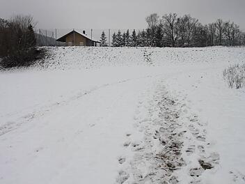 Die Spuren im Schnee zeigen, wie sich die Polizisten am Sonntag dem Fundort näherten. Im Hintergrund das Tennisheim.