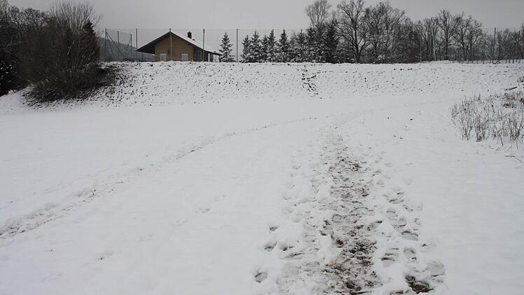 Die Spuren im Schnee zeigen, wie sich die Polizisten am Sonntag dem Fundort näherten. Im Hintergrund das Tennisheim.